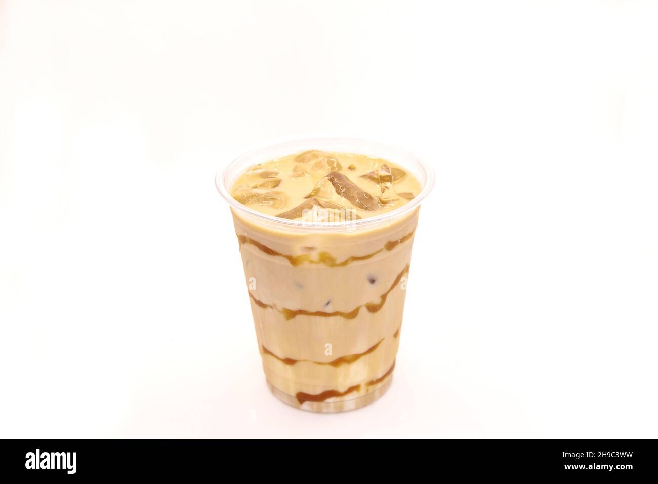 Latte ghiacciato al caramello servito in una tazza di caffè usa e getta. Foto Stock