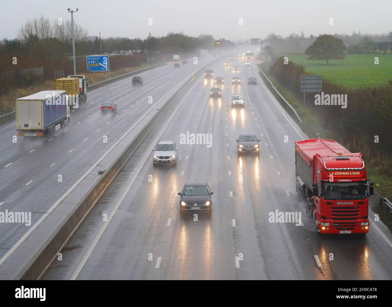 Bromsgrove, Regno Unito. 6 dicembre 2021. Meteo nel Regno Unito: Forti piogge affliggono gli automobilisti mentre Storm barra si avvicina al Regno Unito. Le luci dei veicoli dell'autostrada M5 nelle Midlands sono accese durante il giorno, poiché gli spruzzi d'acqua provenienti dalla pioggia intensa rendono difficile la guida. Crediti: Lee Hudson/Alamy Live News Foto Stock