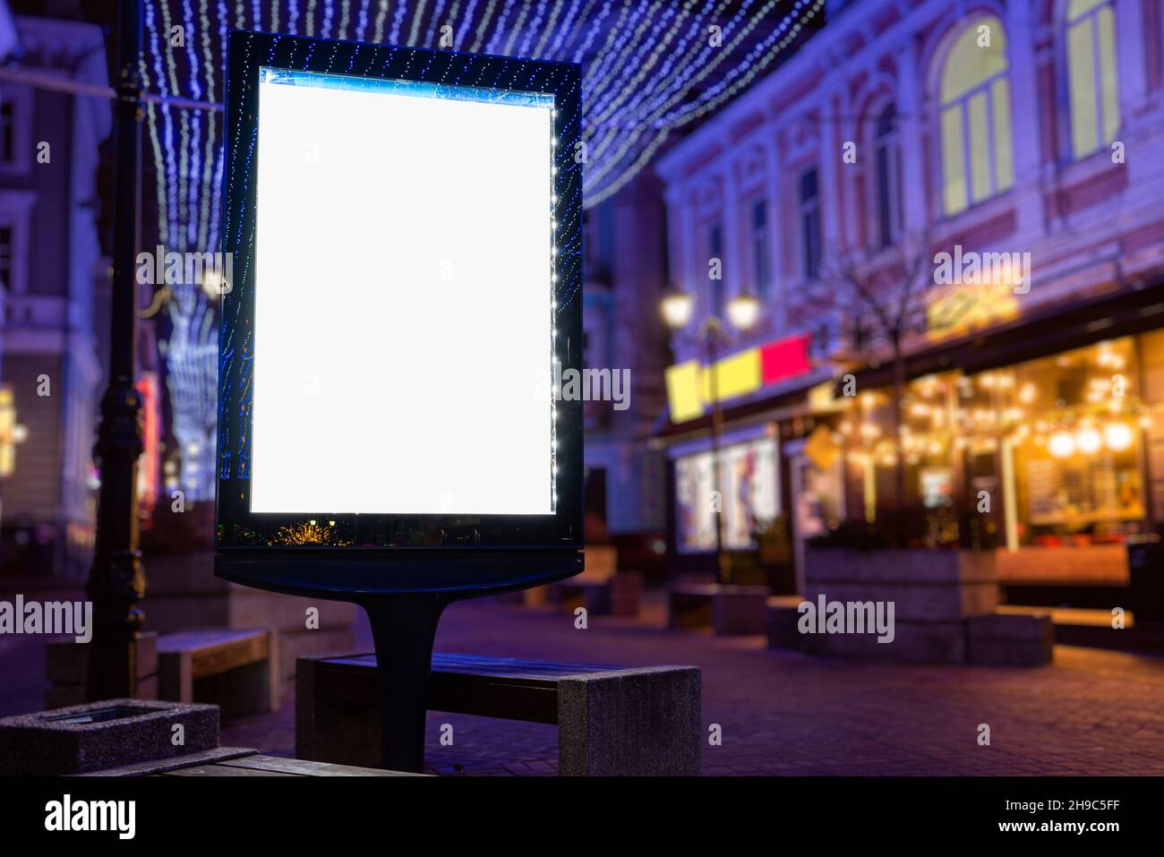 Bianco bianco bianco bianco imbianchino verticale cartellone Street poster su un natale illuminazione sfondo città Foto Stock