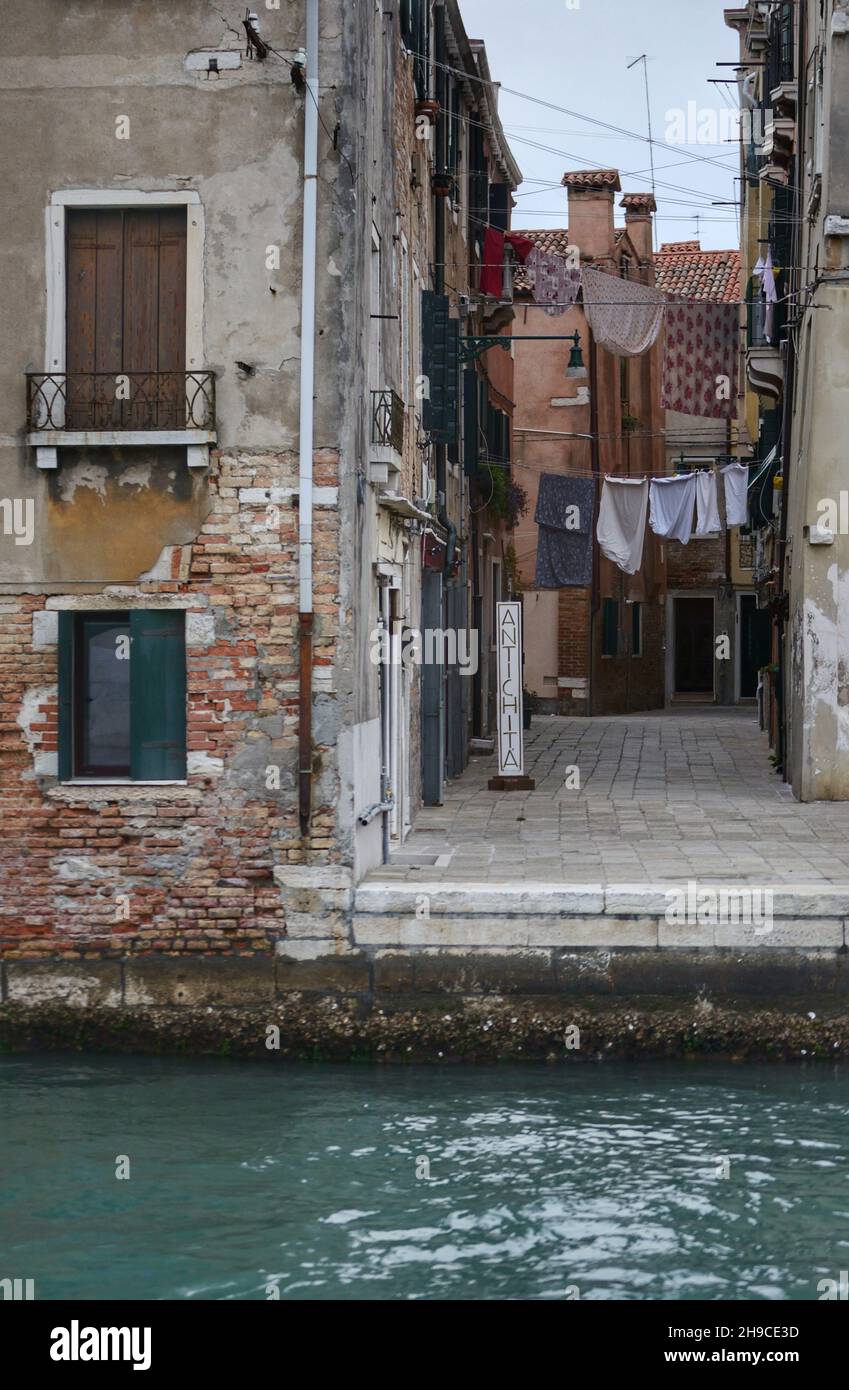 un tipico vicolo popolare con vestiti appesi ai fili tra gli edifici Foto Stock