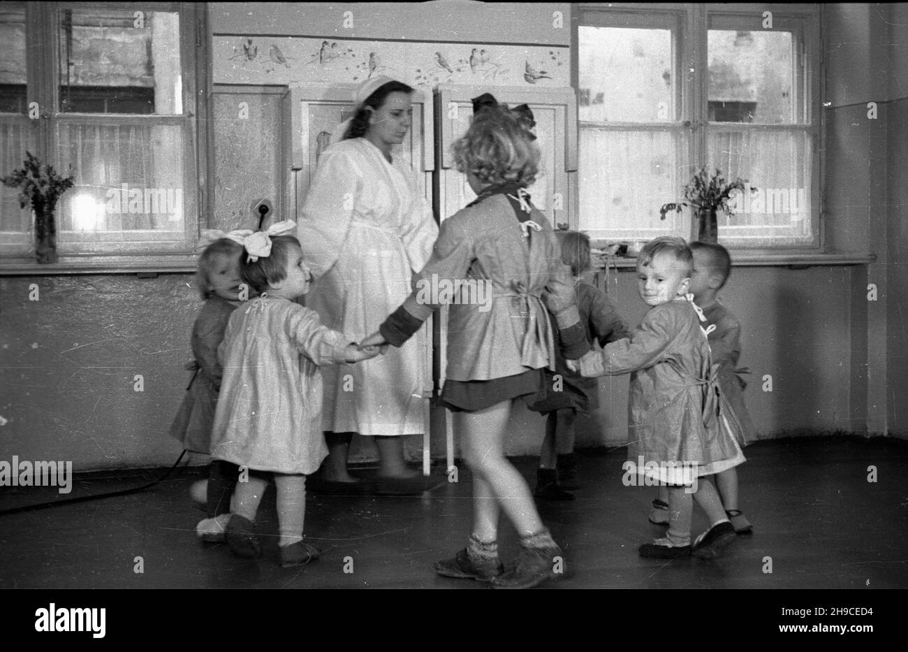 Warszawa, 1947-10. Przyzak³adowy ¿³obek w fabryce czekolady Franciszek Fuchs i Synowie przy ul. Topiel 12. NZ. Oppiekunka bawi siê z dzieæmi. mb/gr PAP Dok³adny dzieñ wydarzenia nieustalony. Varsavia, 1947 ottobre. Un'insenatura di lavoro presso la fabbrica di cioccolato Franciszek Fuchs e figli al 12 Topiel Street. Nella foto: Un chaperone che gioca con i bambini. mb/gr PAP Foto Stock