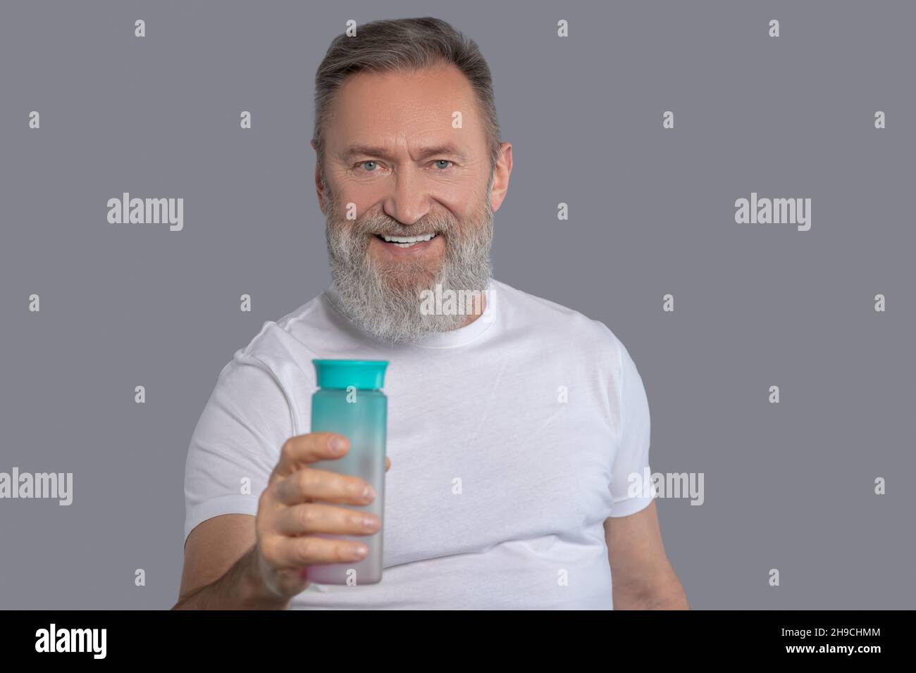 Uomo bearded che tiene una bottiglia di acqua Foto Stock