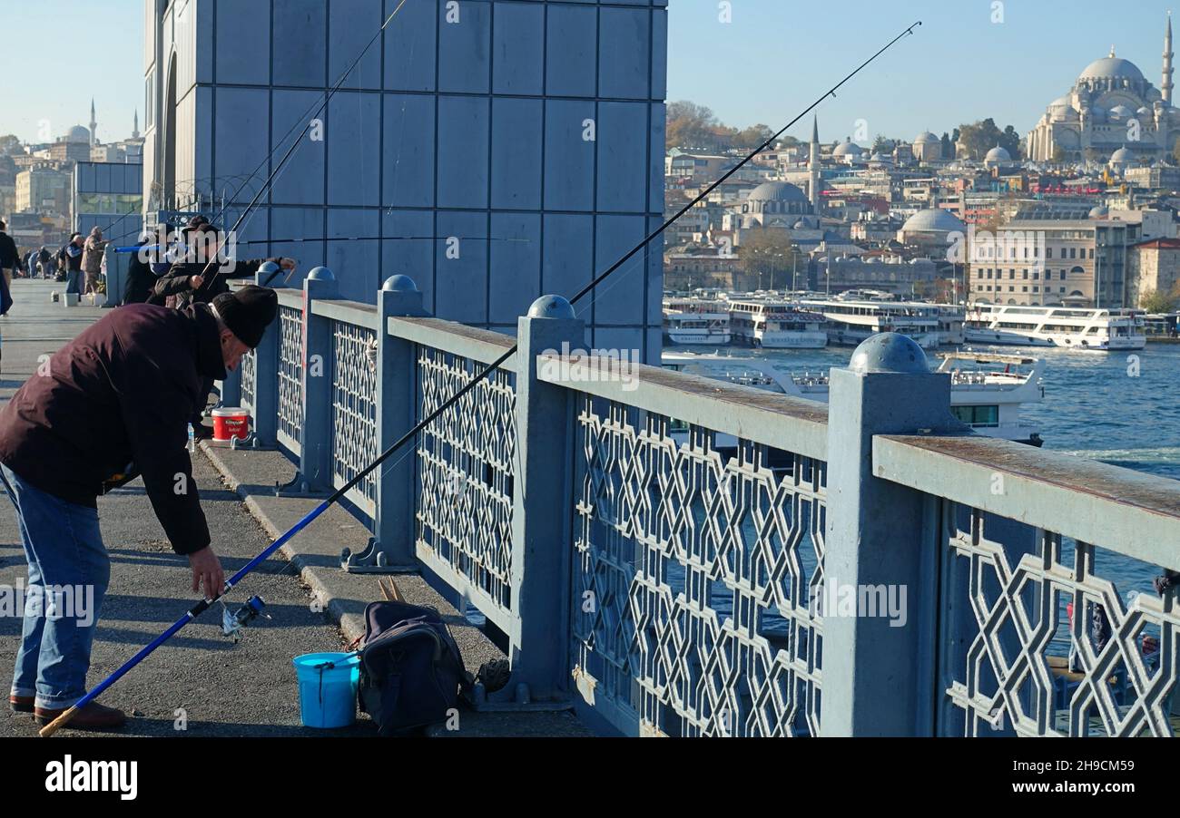 Pescatore con canne da pesca sul ponte più famoso di Istanbul - in inverno Foto Stock