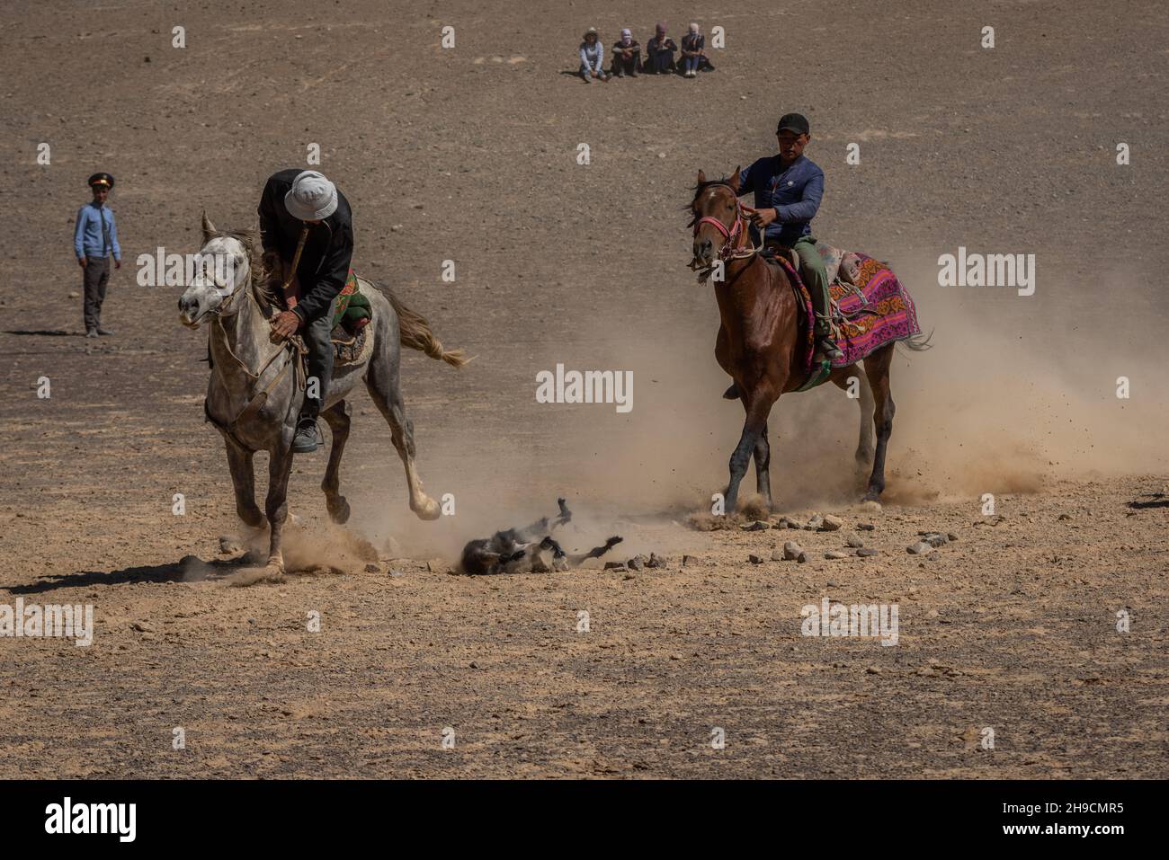 Cavalieri che gareggiano nello sport tradizionale di 'ulak-tartysh-buzkashi' - polo di capra al festival del cavallo di Murghab, in Tagikistan nell'agosto 2019 Foto Stock