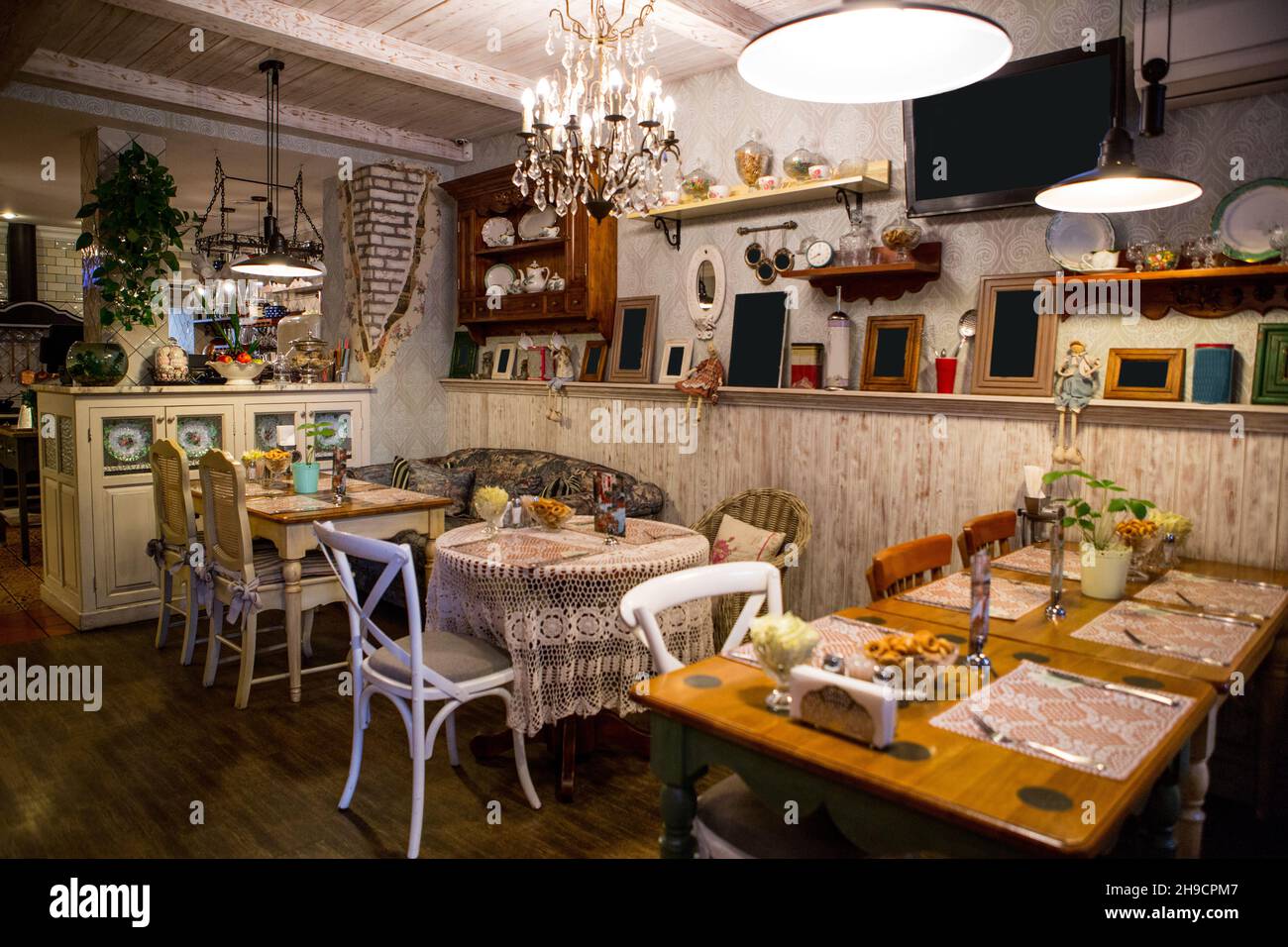 Interno del ristorante in stile country. Accogliente ristorante in stile francese con cornici vuote per dipinti e fotografie sulle pareti Foto Stock