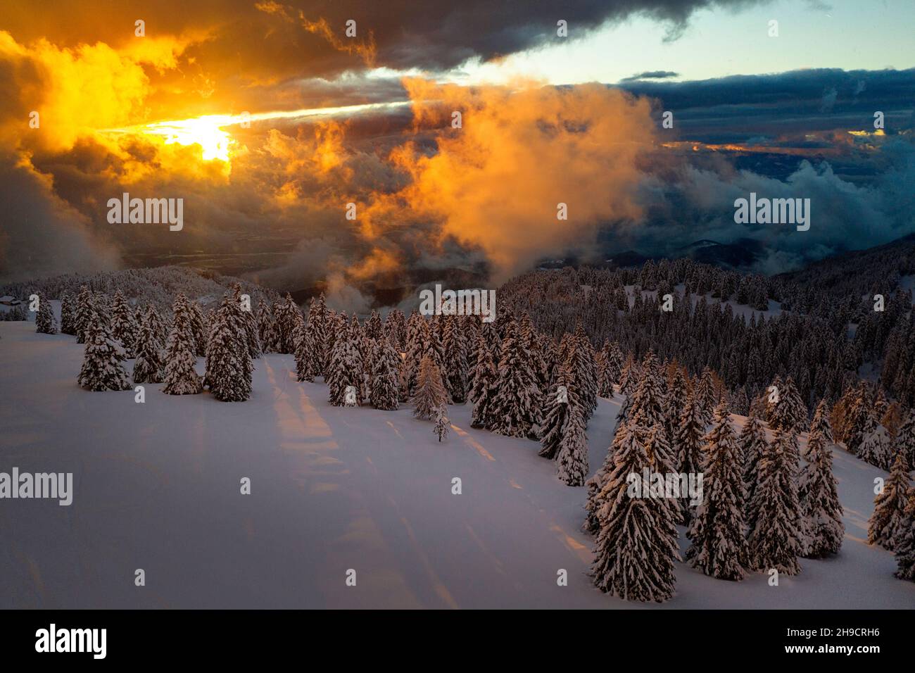 Fantastico paesaggio serale con spettacolare cielo arancione e scena invernale con alberi innevati, Krvavec, Slovenia, Europa Foto Stock