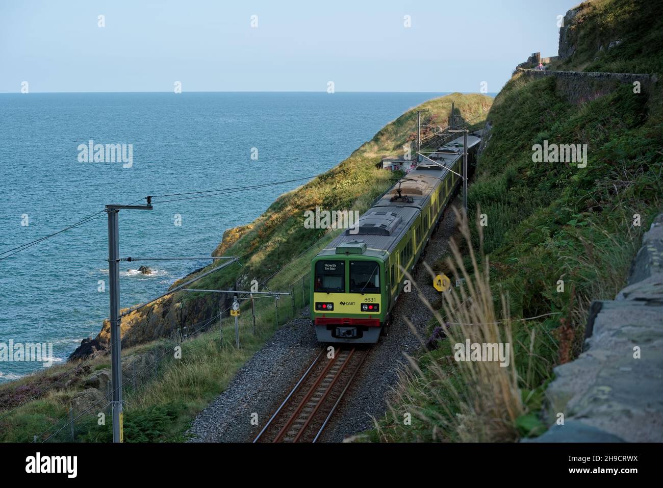 BRAY, IRLANDA - 27 agosto 2021: Treno elettrico DART (Dublin Area Rapid Transit) sulla linea ferroviaria costiera di Bray Head vista da Bray alla scogliera di Graystones Foto Stock