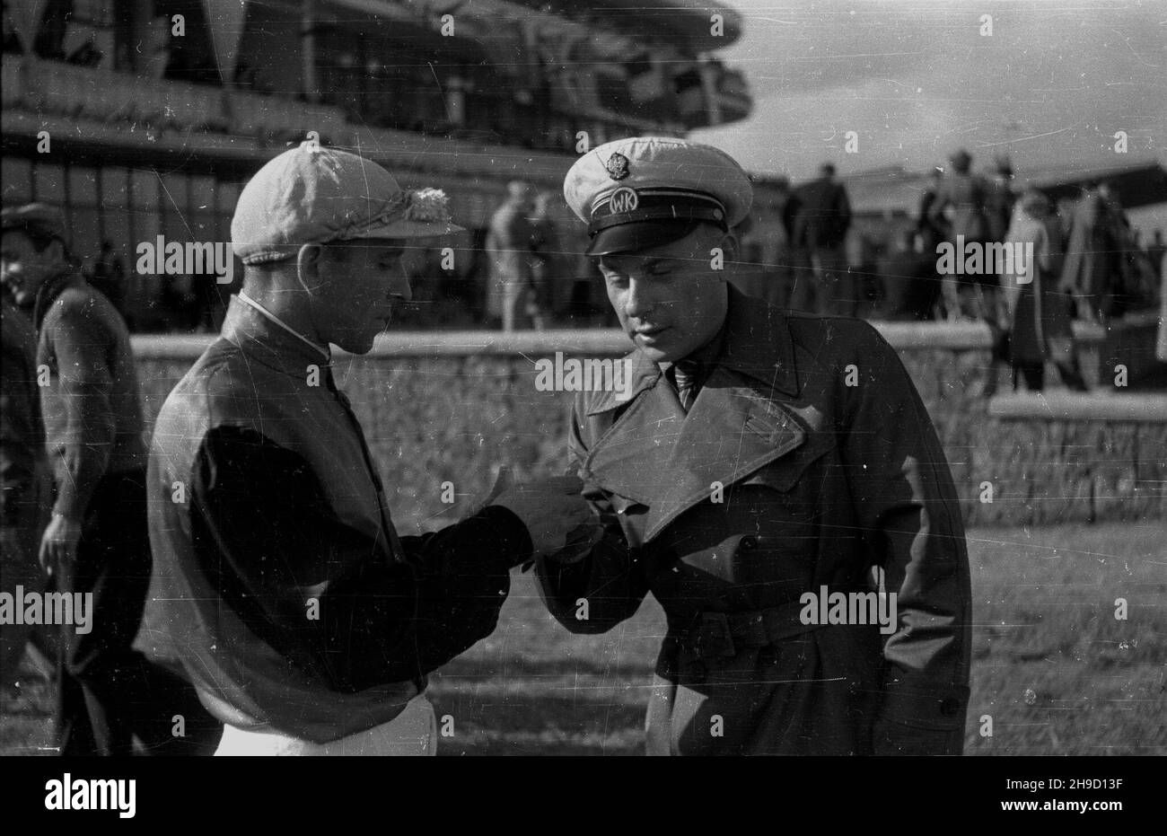 Warszawa, 1947-09-01. Pierwsze powojenne derby na torze wyœcigów konnych na S³u¿ewcu. NZ. d¿okej Stasiak (L) w rozmowie z pracownikiem obs³ugi wyœcigów konnych. ka PAP Varsavia, 1 settembre 1947. Il primo Derby del dopoguerra all'ippodromo di Sluzewiec. Nella foto: Jockey Stasiak (a sinistra) parlando con un operatore di servizi di supporto. ka PAP Foto Stock
