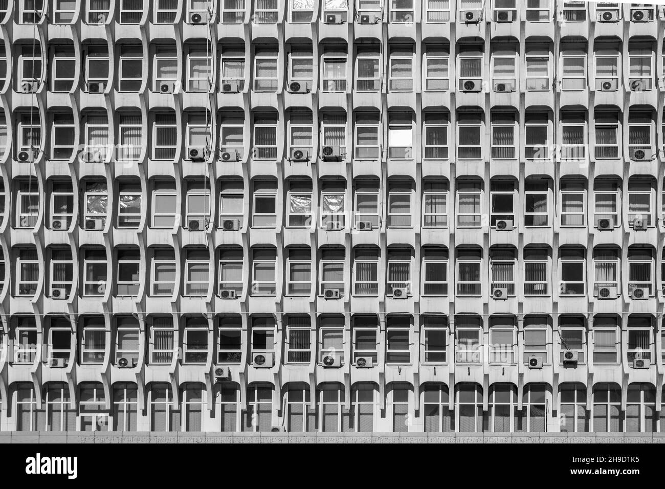 Architettura sovietica. Facciata di un edificio grigio con finestre sullo sfondo Foto Stock