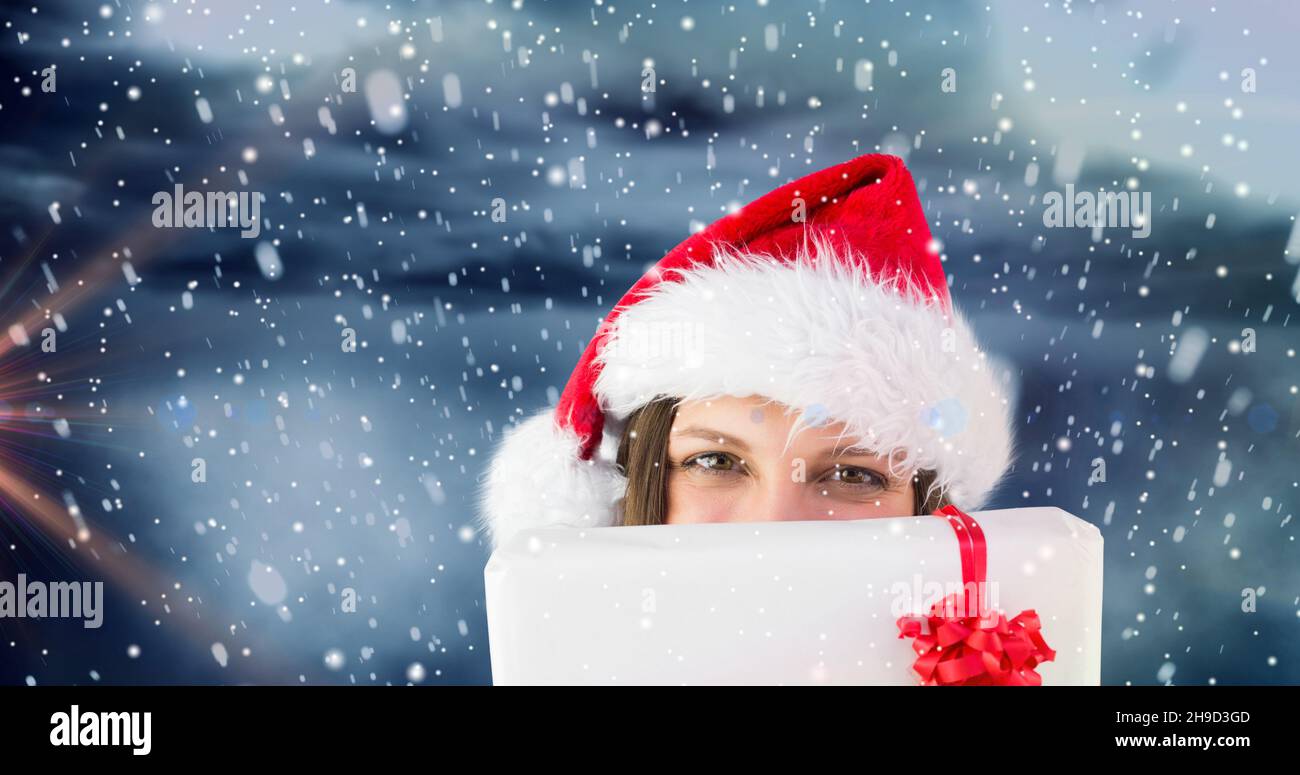 Composizione della donna in santa cappello con regalo di natale su sfondo nevoso, spazio copia Foto Stock