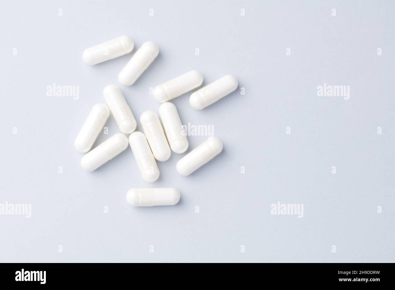 Capsule di arginina. Sfondo carta luminoso. Messa a fuoco soft. Vista dall'alto. Primo piano. Spazio di copia. Foto Stock