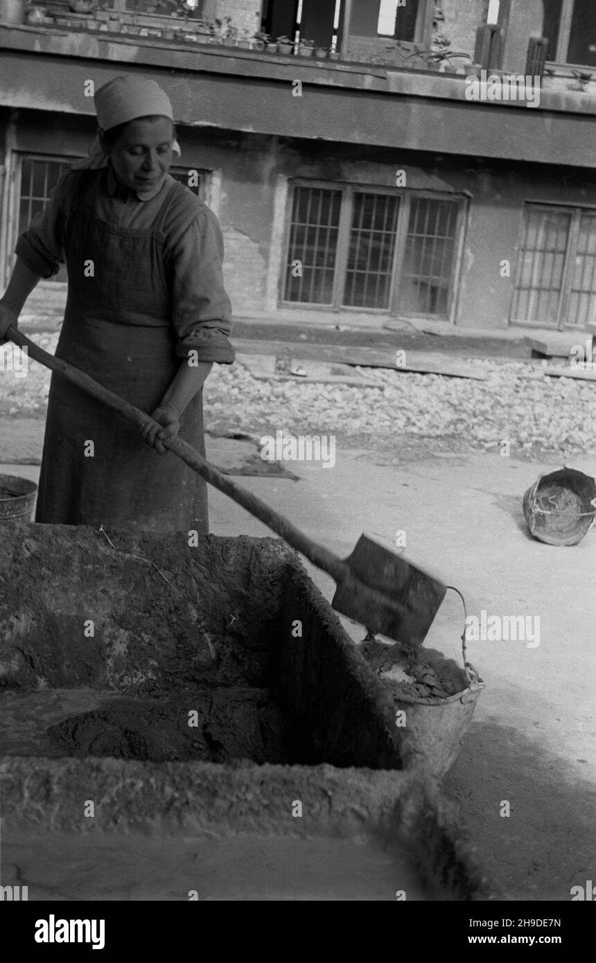 Warszawa, 1947-10. Zgromadzenie Sióstr Urszulanek serca Jezusa Konaj¹cego, zwanych te¿ urszulankami szarymi. SS. Urszulanki odbudowuj¹ Spalonia po Powstaniu Warszawskim swój dom zakonny na Powiœlu. NZ. Jedna z sióstr ³aduje zaprawê do kube³ka. wb/gr PAP Dok³adny dzieñ wydarzenia nieustalony. Varsavia, 1947 ottobre. Congregazione delle Suore Orsoline del cuore di Gesù morente, dette anche Suore Orsoline grigie. Le suore di Orsoline stanno ricostruendo il loro monastero nel distretto di Powisle, bruciato dopo l'insurrezione di Varsavia. Nella foto: Un'incudente che mette mortaio in un secchio. wb/gr PAP Foto Stock