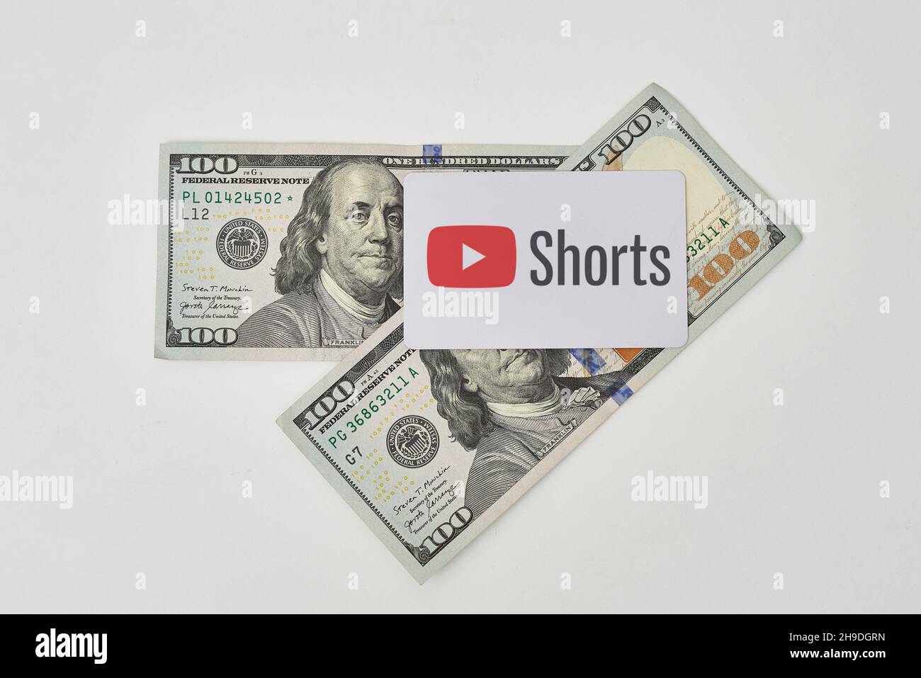 Tashkent, Uzbekistan - 22 Novembre, 2021: Carta pile di dollari USA e Shorts YouTube. YouTube Shorts logo su carta e contanti di dollari americani Foto Stock