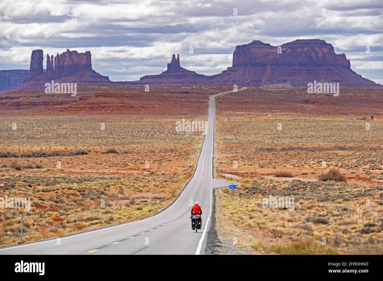 Forrest Gump Point e il ciclista solitario sull'autostrada 163 Scenic Drive, strada dritta che conduce a Monument Valley, San Juan County, Utah, Stati Uniti, USA Foto Stock