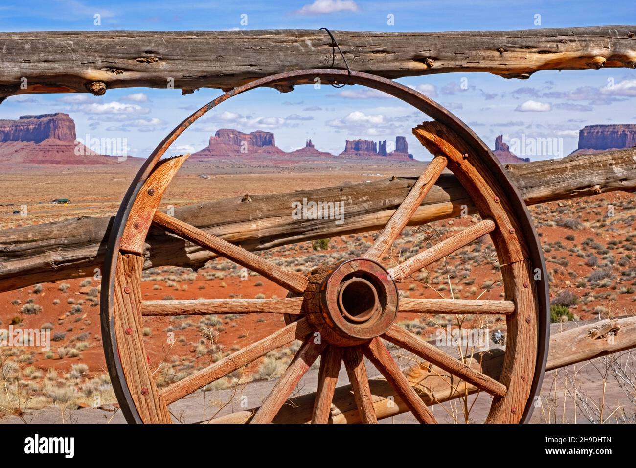Buttes of Monument Valley visto attraverso la vecchia ruota di legno del carro, San Juan County, Utah, Stati Uniti, USA Foto Stock