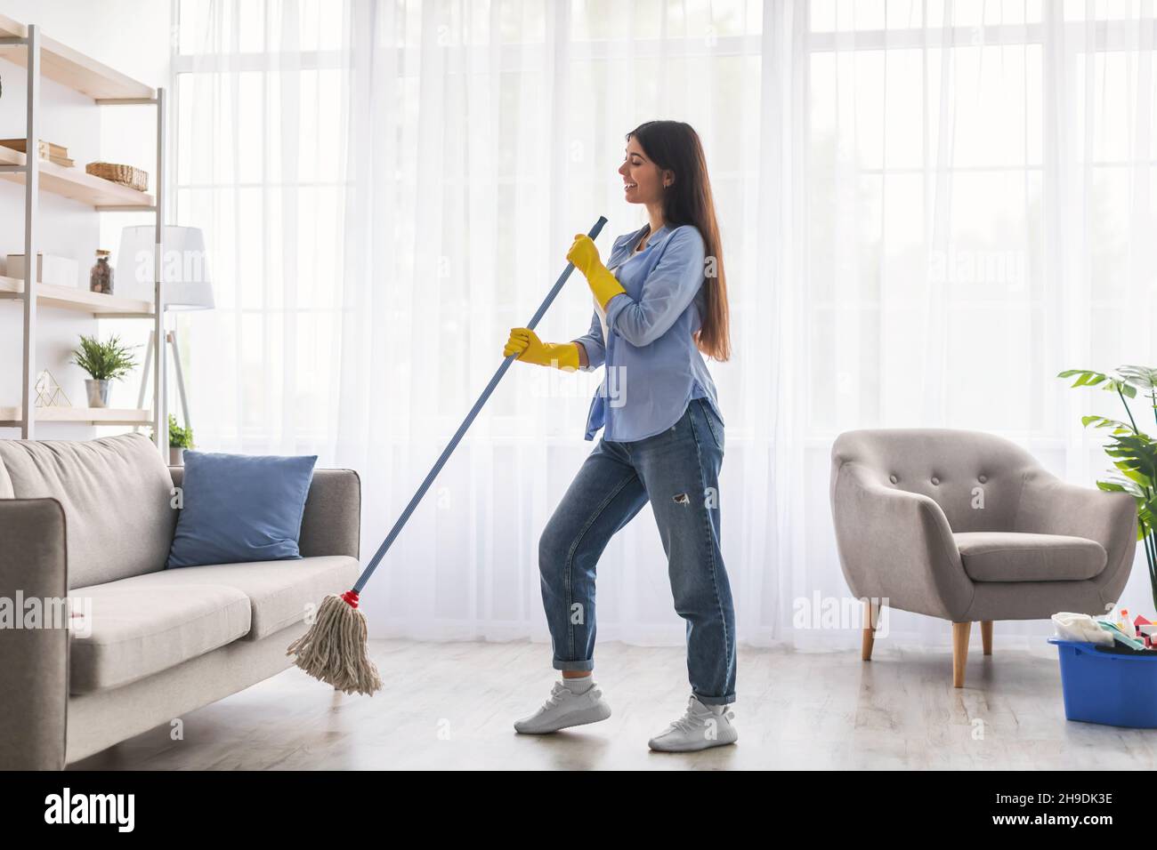 Pulizia, canto e ascolto di musica in cucina con cuffie. Donna nera a casa  facendo faccende domestiche, igiene e lavori domestici mentre streami Foto  stock - Alamy