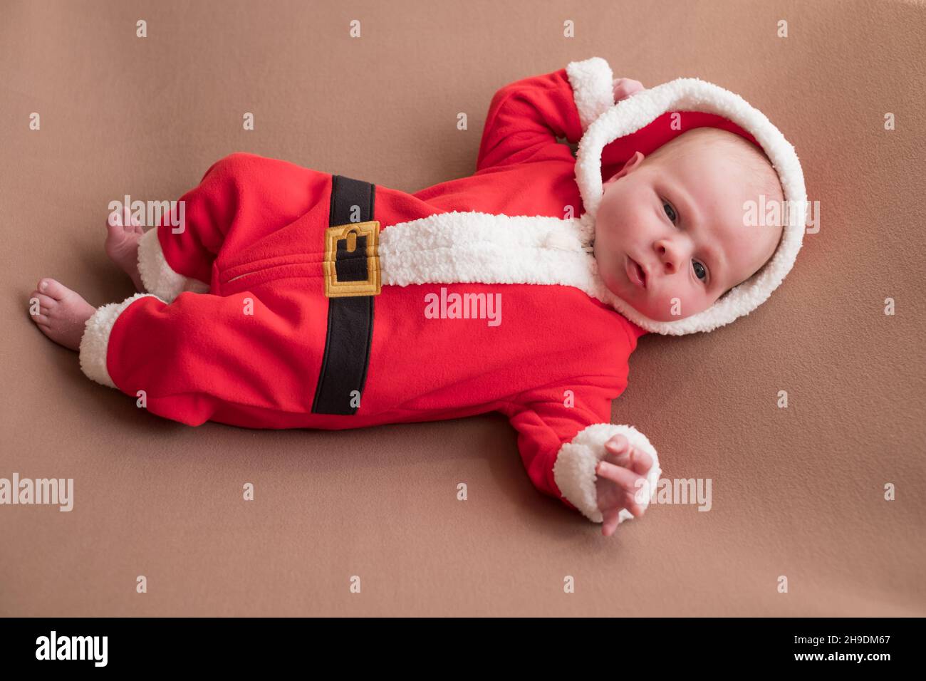 Ragazza neonata vestita in costume di babbo natale guardando la macchina  fotografica con il volto confuso Foto stock - Alamy