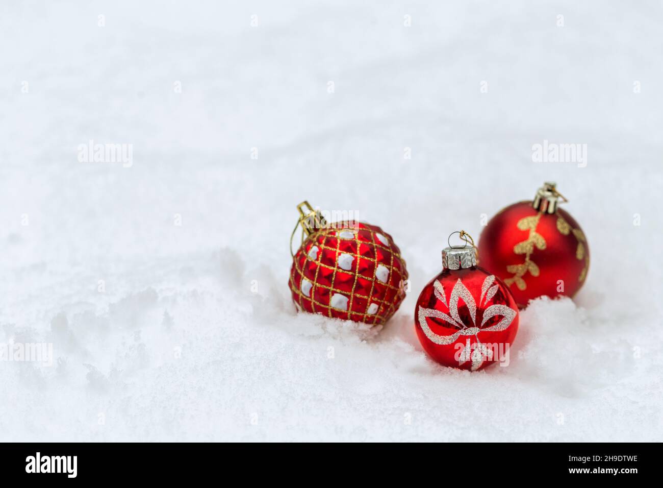 Palline rosse di Natale su sfondo di neve, banner di Natale Foto Stock