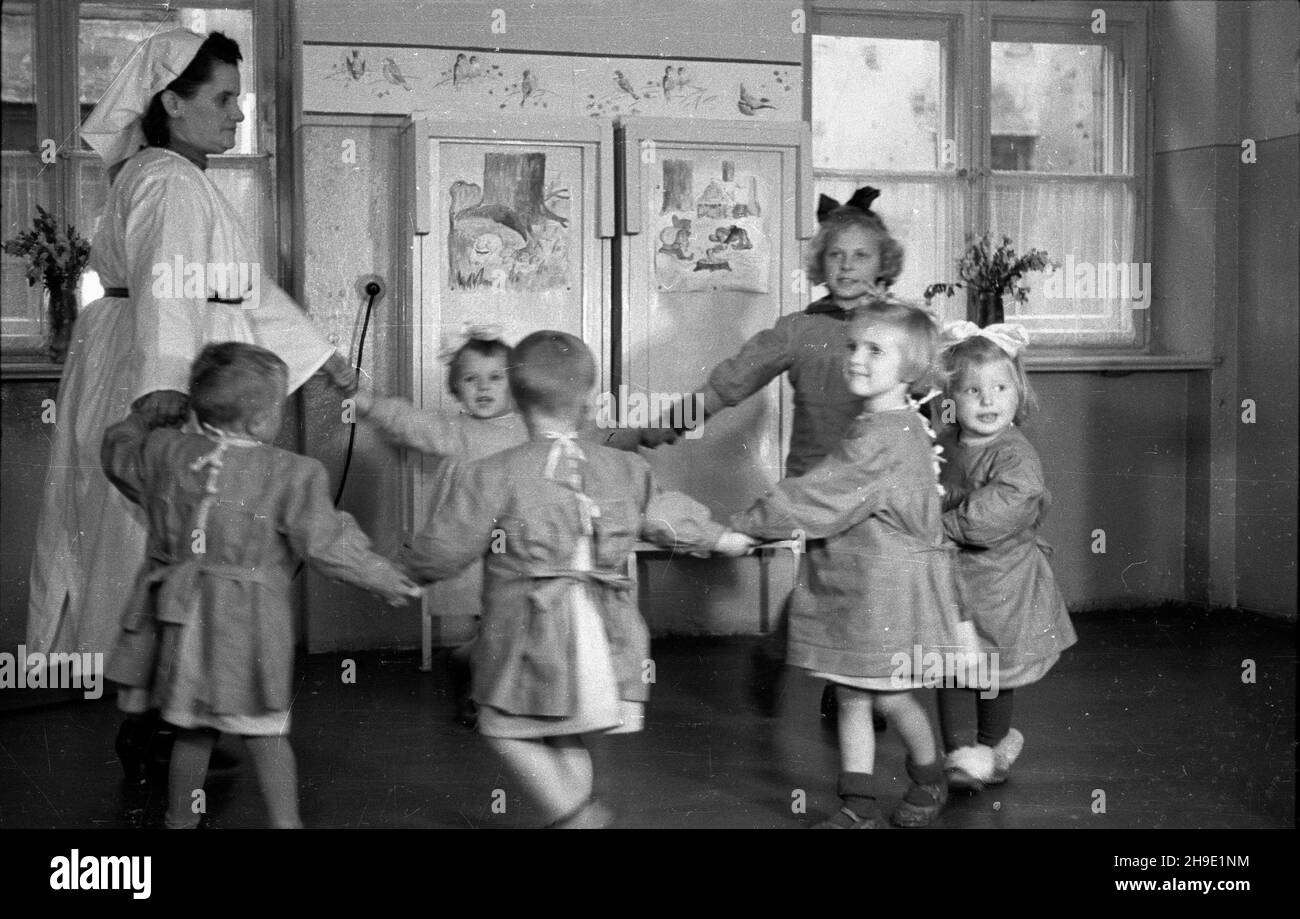 Warszawa, 1947-10. Przyzak³adowy ¿³obek w fabryce czekolady Franciszek Fuchs i Synowie przy ul. Topiel 12. NZ. Oppiekunka bawi siê z dzieæmi. mb/gr PAP Dok³adny dzieñ wydarzenia nieustalony. Varsavia, 1947 ottobre. Un'insenatura di lavoro presso la fabbrica di cioccolato Franciszek Fuchs e figli al 12 Topiel Street. Nella foto: Un chaperone che gioca con i bambini. mb/gr PAP Foto Stock