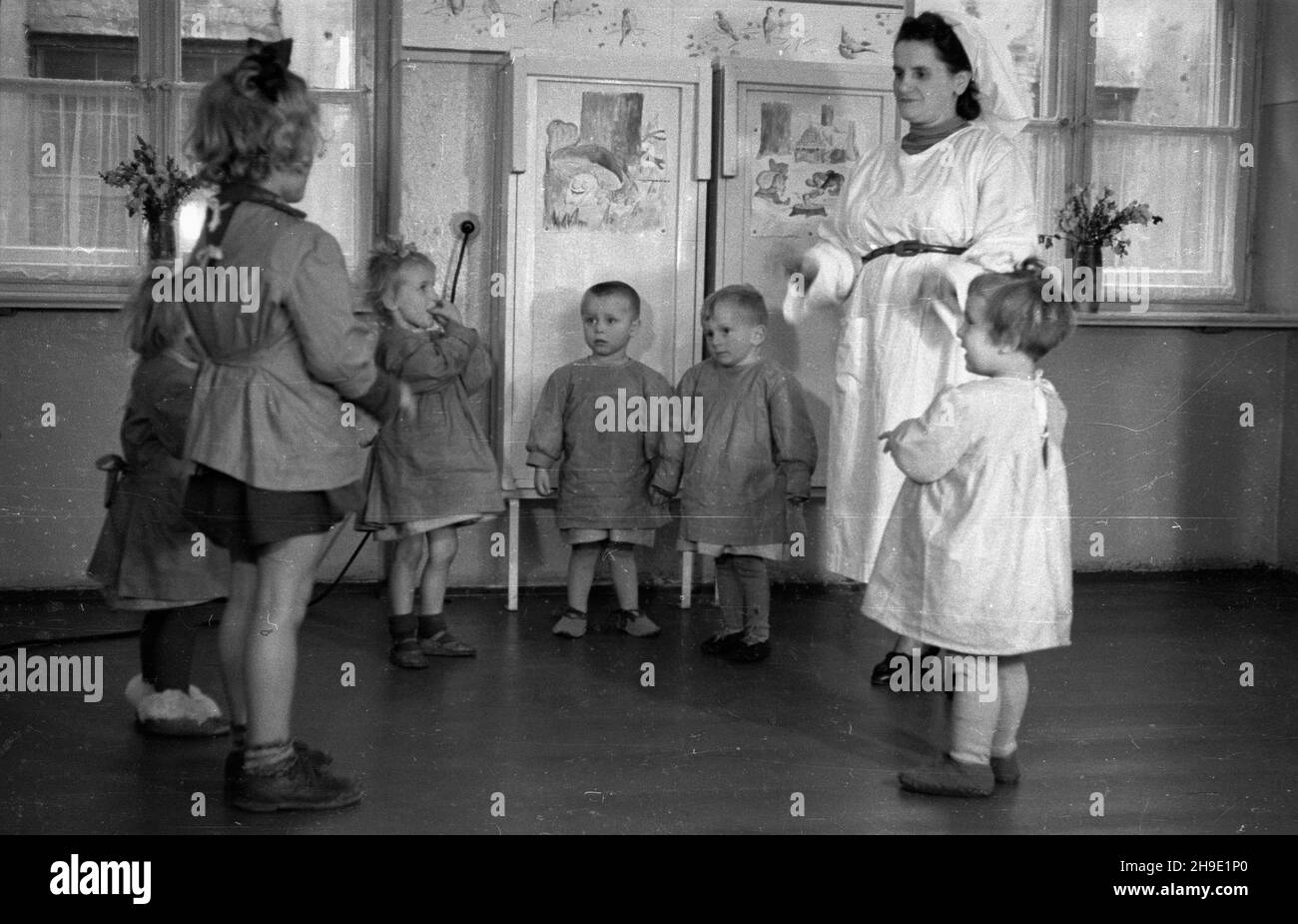 Warszawa, 1947-10. Przyzak³adowy ¿³obek w fabryce czekolady Franciszek Fuchs i Synowie przy ul. Topiel 12. NZ. Oppiekunka bawi siê z dzieæmi. mb/gr PAP Dok³adny dzieñ wydarzenia nieustalony. Varsavia, 1947 ottobre. Un'insenatura di lavoro presso la fabbrica di cioccolato Franciszek Fuchs e figli al 12 Topiel Street. Nella foto: Un chaperone che gioca con i bambini. mb/gr PAP Foto Stock