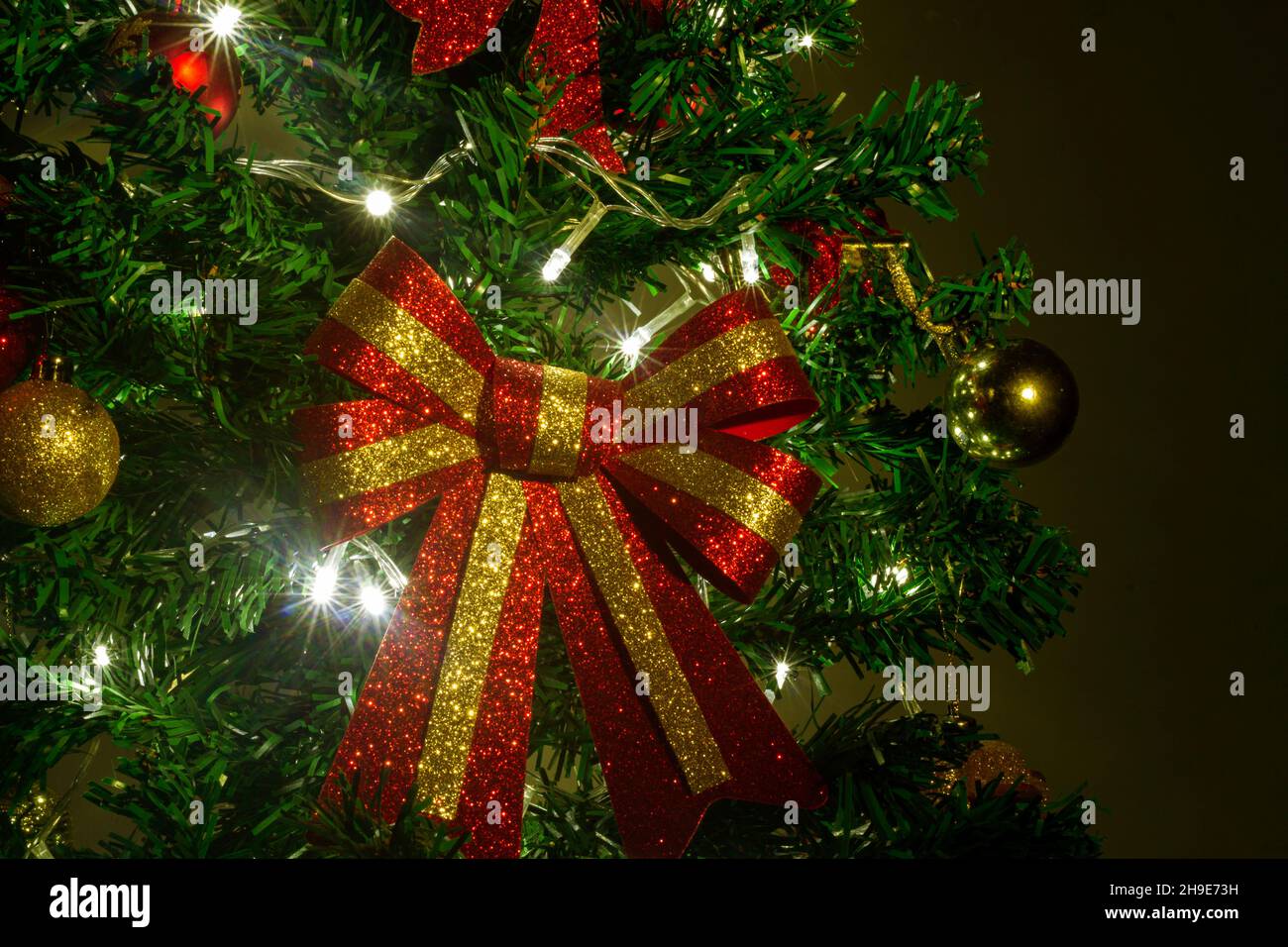Primo piano di decorazioni su un albero di Natale con luci accese Foto Stock