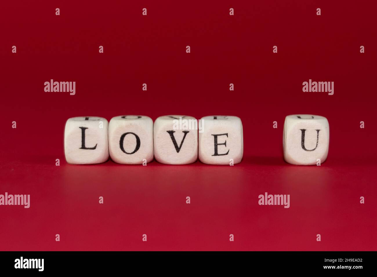 Cubi di legno con le parole TI AMANO su sfondo rosso. San Valentino concetto Foto Stock