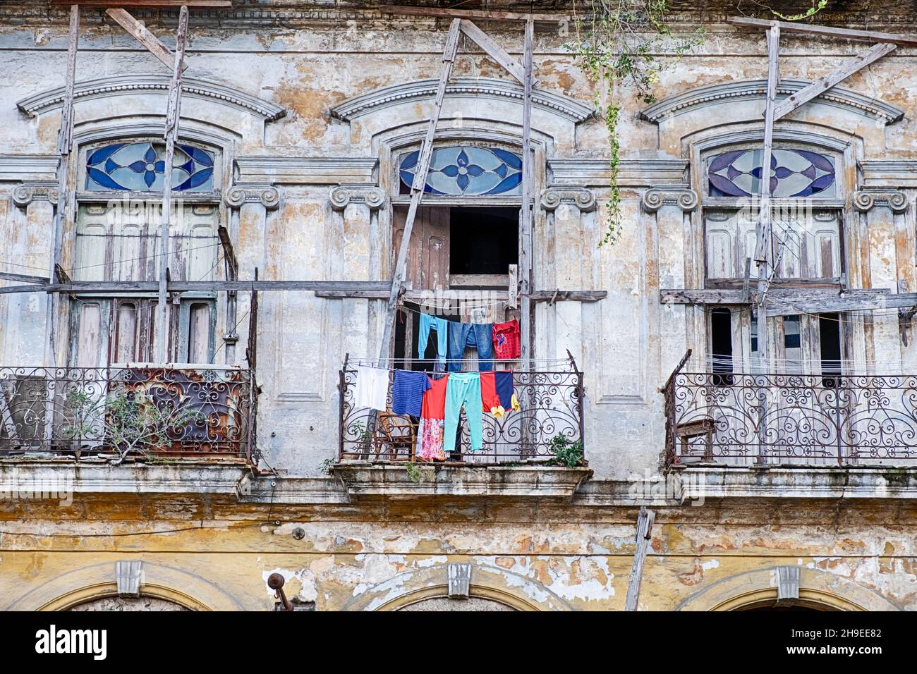 Una finestra in un vecchio edificio di appartamenti a l'Avana, Cuba è piena di vestiti che si asciugano all'aria aperta. Foto Stock