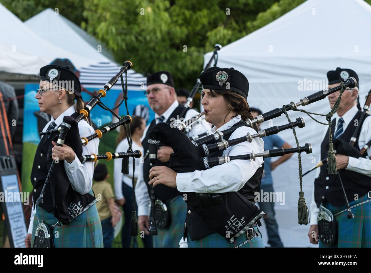 I bagpipers maschili e femminili in regalia completa si preparano ad esibirsi ad un festival scozzese a Moab, Utah. Foto Stock