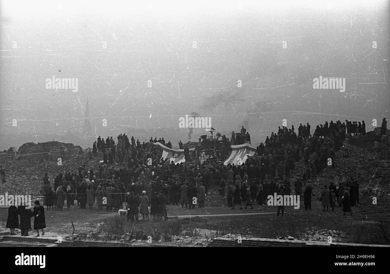 Warszawa, 1947-11-01. Msza ¿a³obna na gruzach Pawiaka w ho³dzie zamordowanym w niemieckich wiêzieniach i obozach. NZ. Ludzie zgromadzeni na mszy. Przy o³tarzu le¿¹ pasiate sztandary Zwi¹zku By³ych WiêŸniów Politycznych. ps/gr PAP Varsavia, 1 novembre 1947. La messa funeraria in omaggio agli assassinati nelle prigioni tedesche e nei campi di concentramento offerti alle rovine di Pawiak, l'ex prigione. Nella foto: Persone che frequentano la messa. Ai piedi dell'altare giacciono le bandiere con le strisce dell'Associazione degli ex prigionieri politici. ps/gr PAP Foto Stock