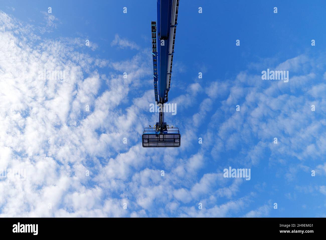 Un braccio Genie S125 si solleva contro un cielo blu nuvoloso Foto Stock