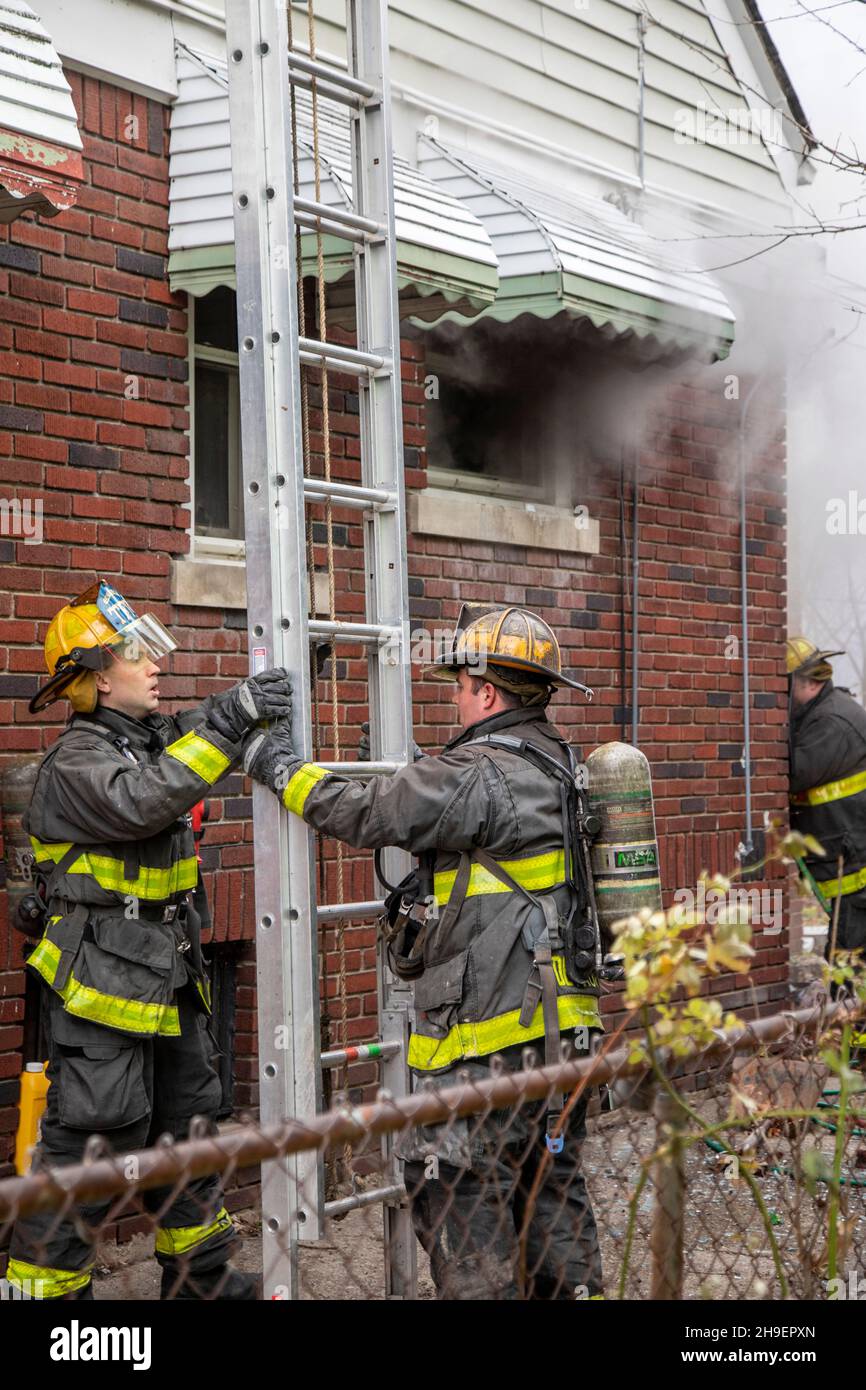 Detroit, Michigan - i vigili del fuoco hanno allestito una scala mentre combattono un incendio che ha danneggiato una casa nel quartiere Morningside di Detroit. Foto Stock