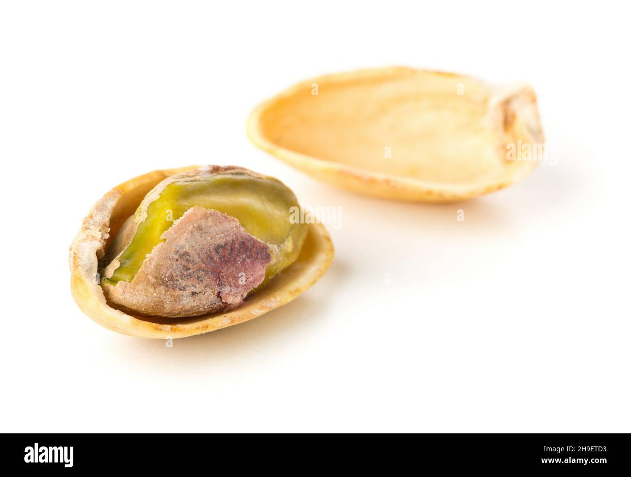 Macro di pistacchio singolo salato, torrefatto verde su sfondo bianco, snack sano cibo, fuoco selettivo Foto Stock