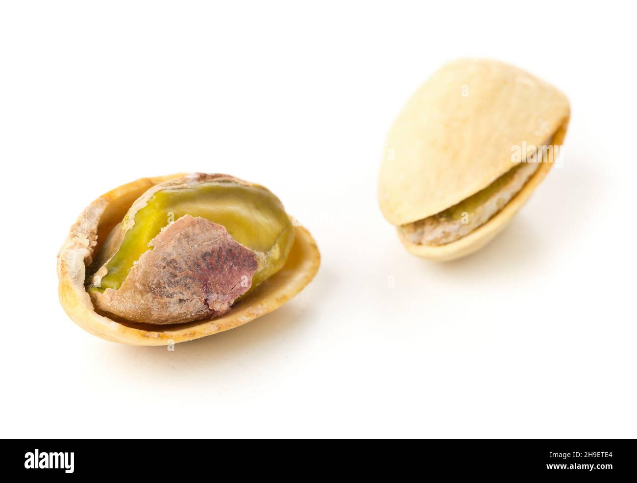 Macro di pistacchio singolo salato, torrefatto verde su sfondo bianco, snack sano cibo, fuoco selettivo Foto Stock