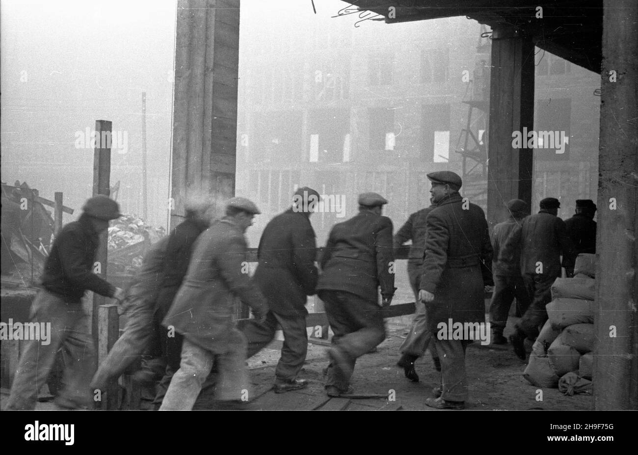 Warszawa, 1948-01. PL. Trzech Krzy¿y. Budowa siedziby Ministerstwa Przemys³u i Handlu. Gmach wg projektu Stanis³awa Rych³owskiego i Stanis³awa Bieñkuñskiego wznoszono w latach 1946-48. W konstrukcji budynku zastosowano nowatorskie rozwi¹zania, m.in. Pustaki produkowane na miejscu z mielonego gruzu (tzw. Gruzobeton). Brigada wspó³zawodnictwie we cieœli uczestnicz¹cych pracy biegnie na stanowiska. po/mgs PAP Dok³adny dzieñ wydarzenia nieustalony. Varsavia, gennaio 1948. Piazza tre croci. Costruzione della sede del Ministero dell'industria e del Commercio. L'edificio progettato da Stanislaw Rychlowski e sta Foto Stock