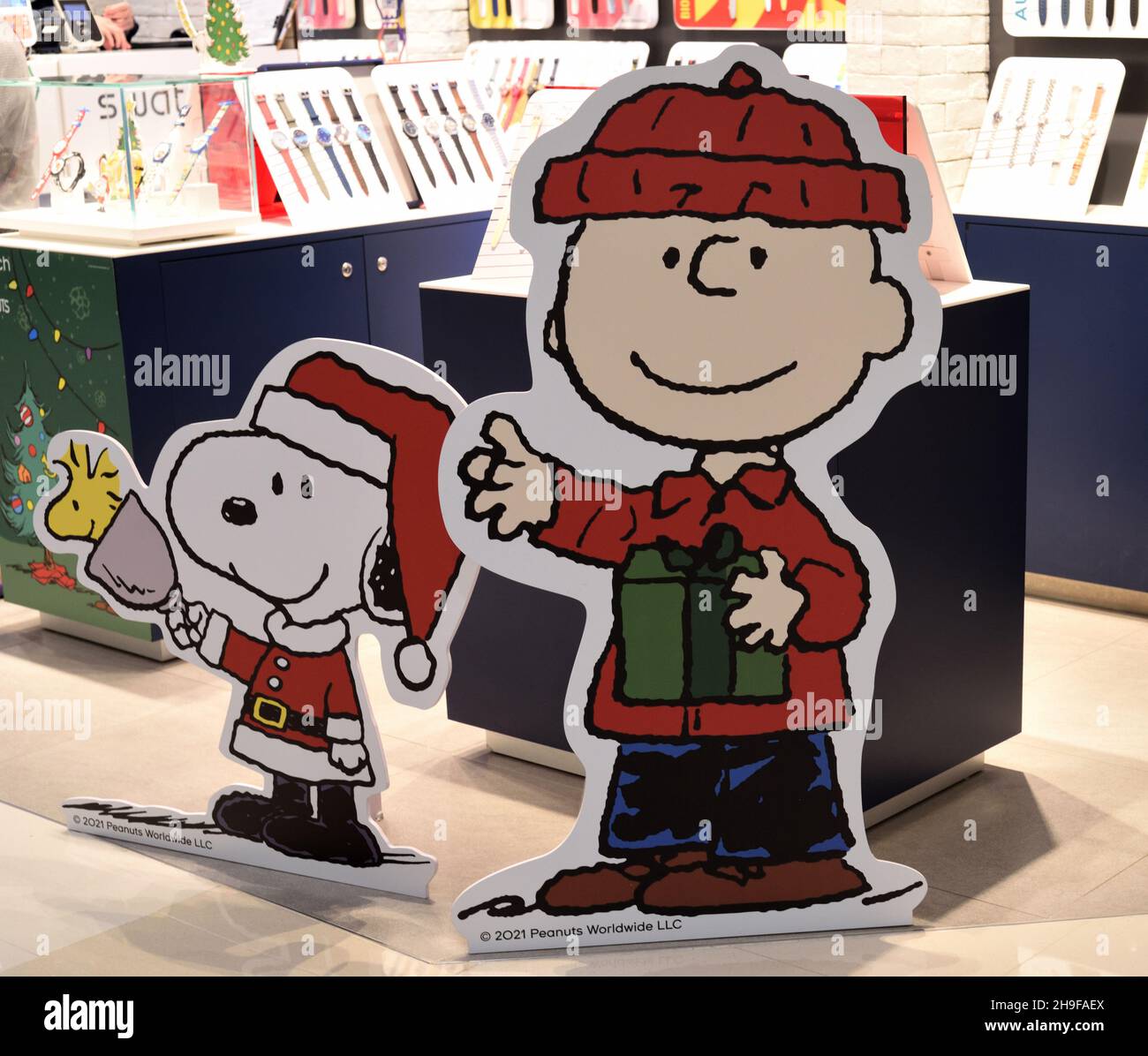 Figure di cartone sorridenti Charlie Brown e Snoopy in costume di Natale per salutare i clienti in una galleria commerciale, Hong Kong. Foto Stock