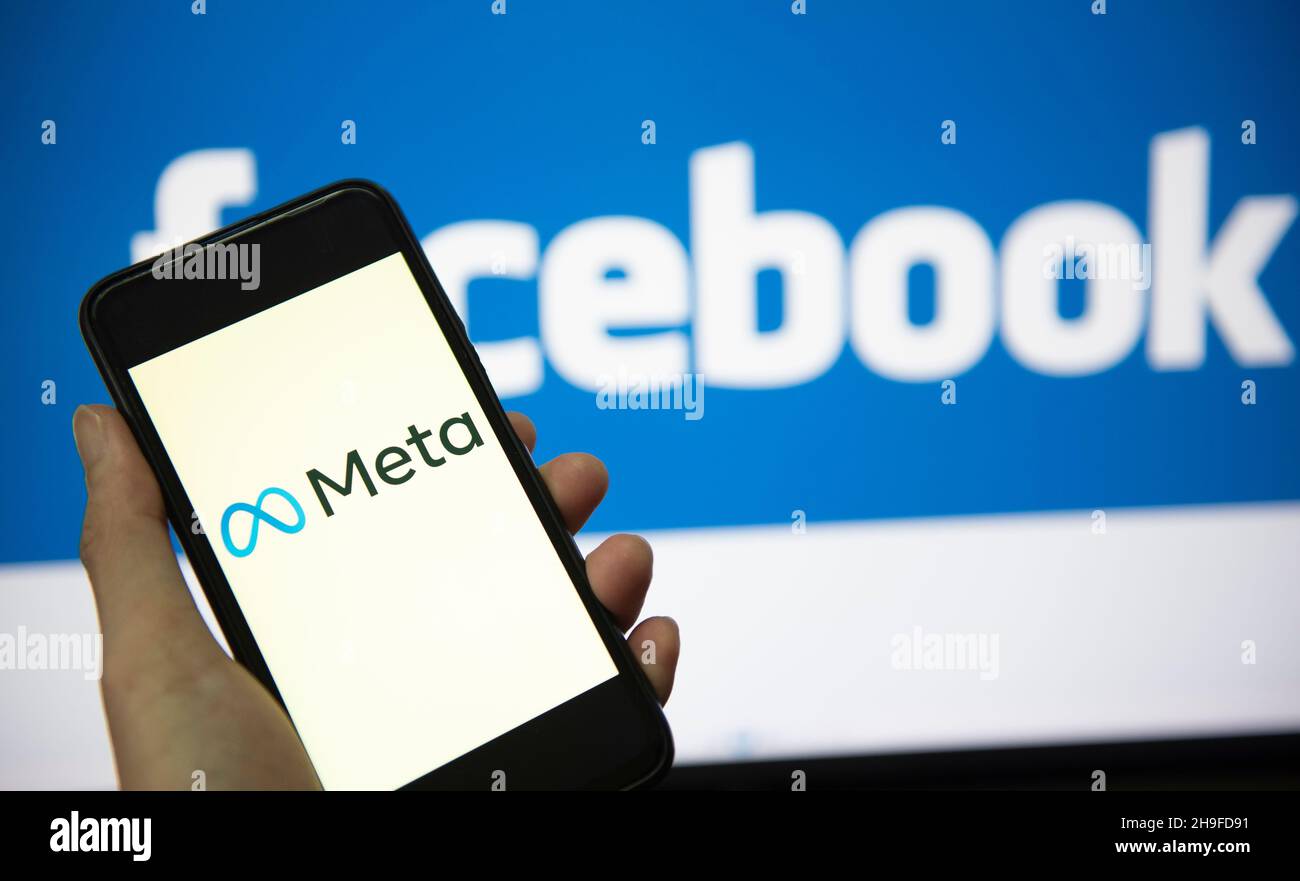 META logo sullo schermo dello smartphone con lancetta e logo facebook sullo sfondo. Nuovo logo aziendale di facebook concetto meta metaverse. Bangkok Thailila Foto Stock