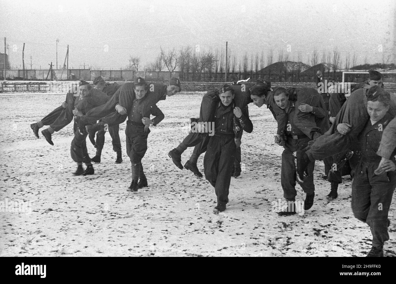 Warszawa, 1948-02. Stadion Wojskowego Klubu Sportowego Legia. Szkolenie rekruckie kadr hufców paramilitarnej Powszechnej Organizacji S³u¿ba Polsce. Przyszli instruktorzy podczas æwiczeñ na boisku (wynoszenie rannego z pola walki). Dok³adny dzieñ wydarzenia nieustalony. bk PAP Varsavia, 1948 febbraio. Lo Stadio del Club militare dello Sport Legia. Reclutare la formazione del personale del Servizio dell'Organizzazione di massa paramilitare in Polonia. Nella foto: Futuri istruttori durante gli esercizi sportivi sul campo. bk PAP Foto Stock