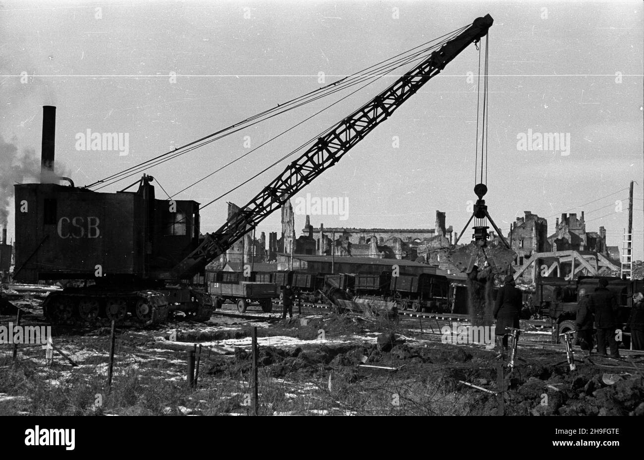 Warszawa, 1948-02. Budowa Trasy Wschód-Zachód. Prace przy rozbiórce wiaduktu Pancera, ³¹cz¹cego stare Miasto z dawnym mostem Kierbedzia. NZ. Tzw. Kopaczka parowa (L) i kolejka w¹skotorowa s³u¿¹ca do wywozu gruzu. uu PAP Dok³adny dzieñ wydarzenia nieustalony. Varsavia, 1948 febbraio. Costruzione del percorso W-Z (est-ovest). La demolizione del cavalcavia Pancera che collega la Città Vecchia con l'ex ponte di Kierbedzia. In figura: Escavatore Steem (sinistro) e treno a carreggiata stretta per la rimozione delle macerie. uu PAP Foto Stock