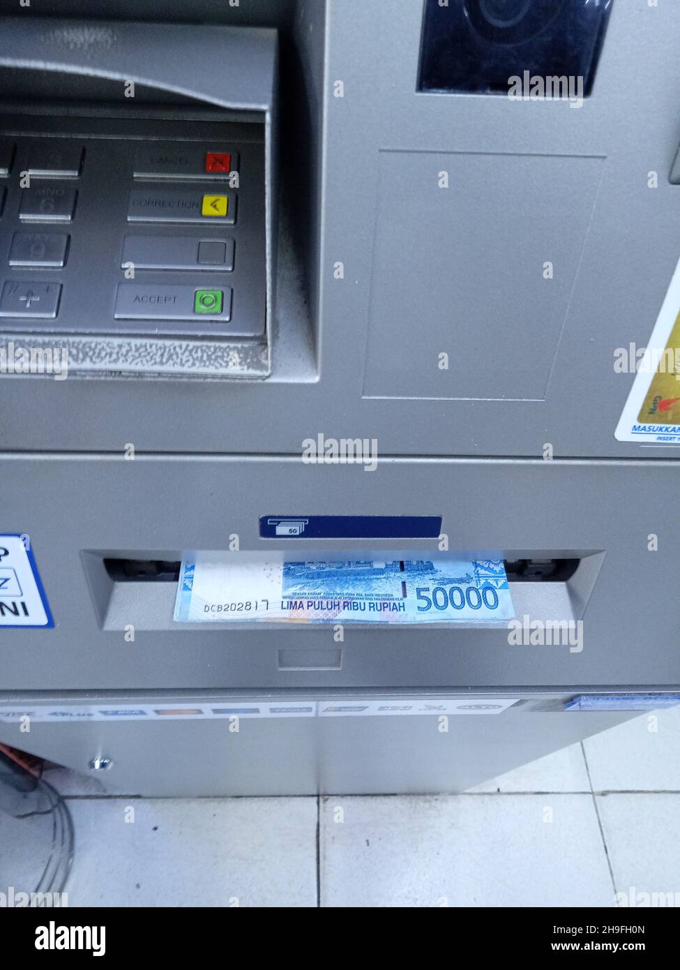 Foto editoriale, Indonesia, Giacarta Est, 02 ottobre 2021, uomo prendere soldi 50000 rupia a ATM BCA Foto Stock