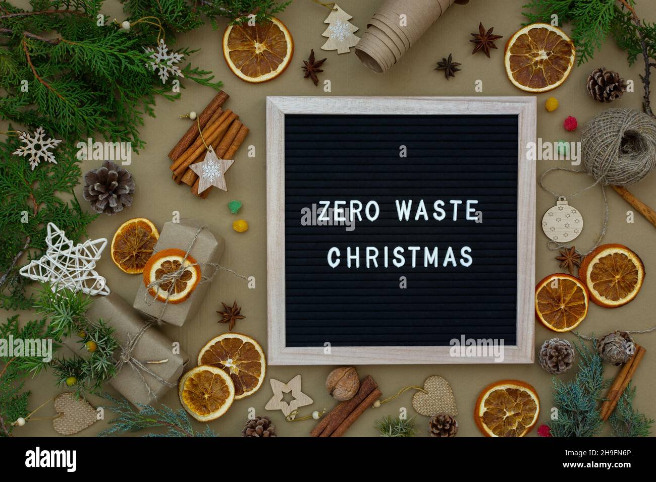 Concetto di Natale senza sprechi. Materiali naturali legno, carta, rami di abete, coni, noci, agrumi secchi, cannella. Cornice con iscrizione. Eco- Foto Stock