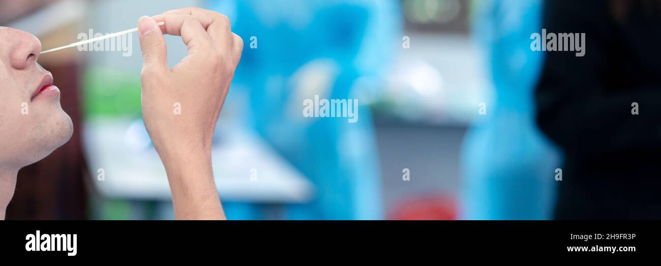 Il test MAN Swab COVID-19 con ATK o kit Rapid Antigen Test con tampone nasale di cotone Foto Stock