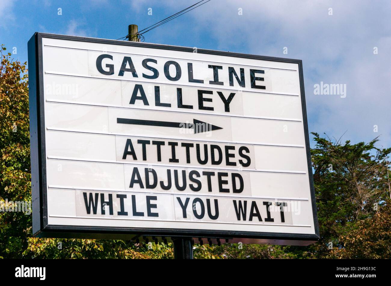 Benzina Alley segno humorous al Revival di Goodwood 2014. Atteggiamenti regolati mentre attendete Foto Stock