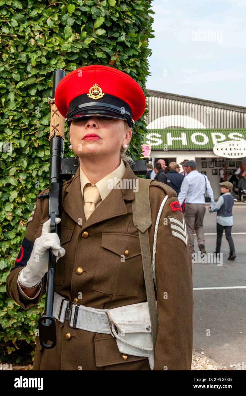 Donna in vintage, costume militare d'epoca della polizia militare con pistola al Goodwood Revival Foto Stock