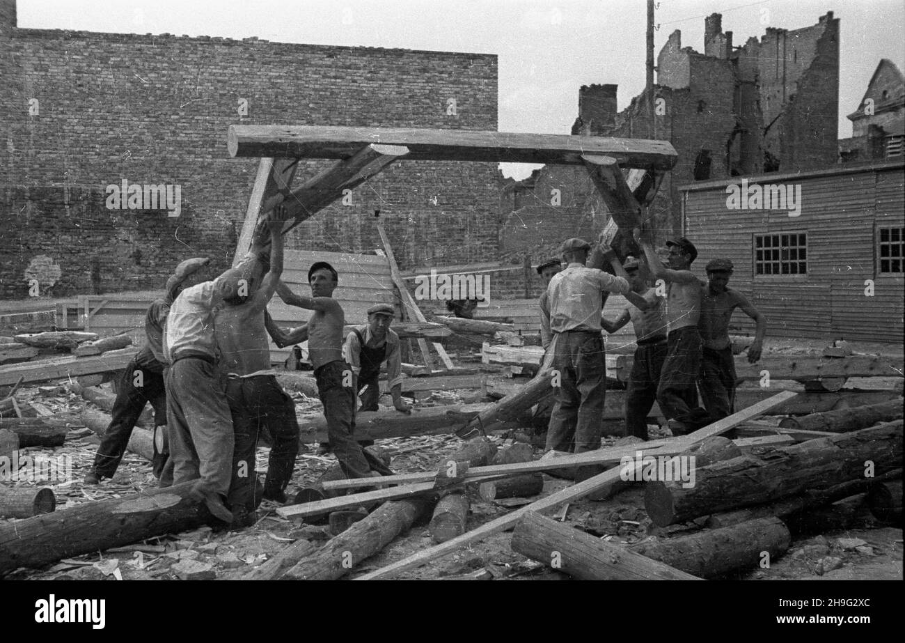 Warszawa, 1948-06. Robotnicy podnosz¹ drewnian¹ konstrukcjê na placu Zamkowym podczas budowy trasy W-Z (trasy Wschód-Zachód). wb PAP Dok³adny dzieñ wydarzenia nieustalony. Varsavia, giugno 1948. I lavoratori tagliano il legno in piazza Zamkowy durante la costruzione della strada W-Z (Est-Ovest). wb PAP Foto Stock