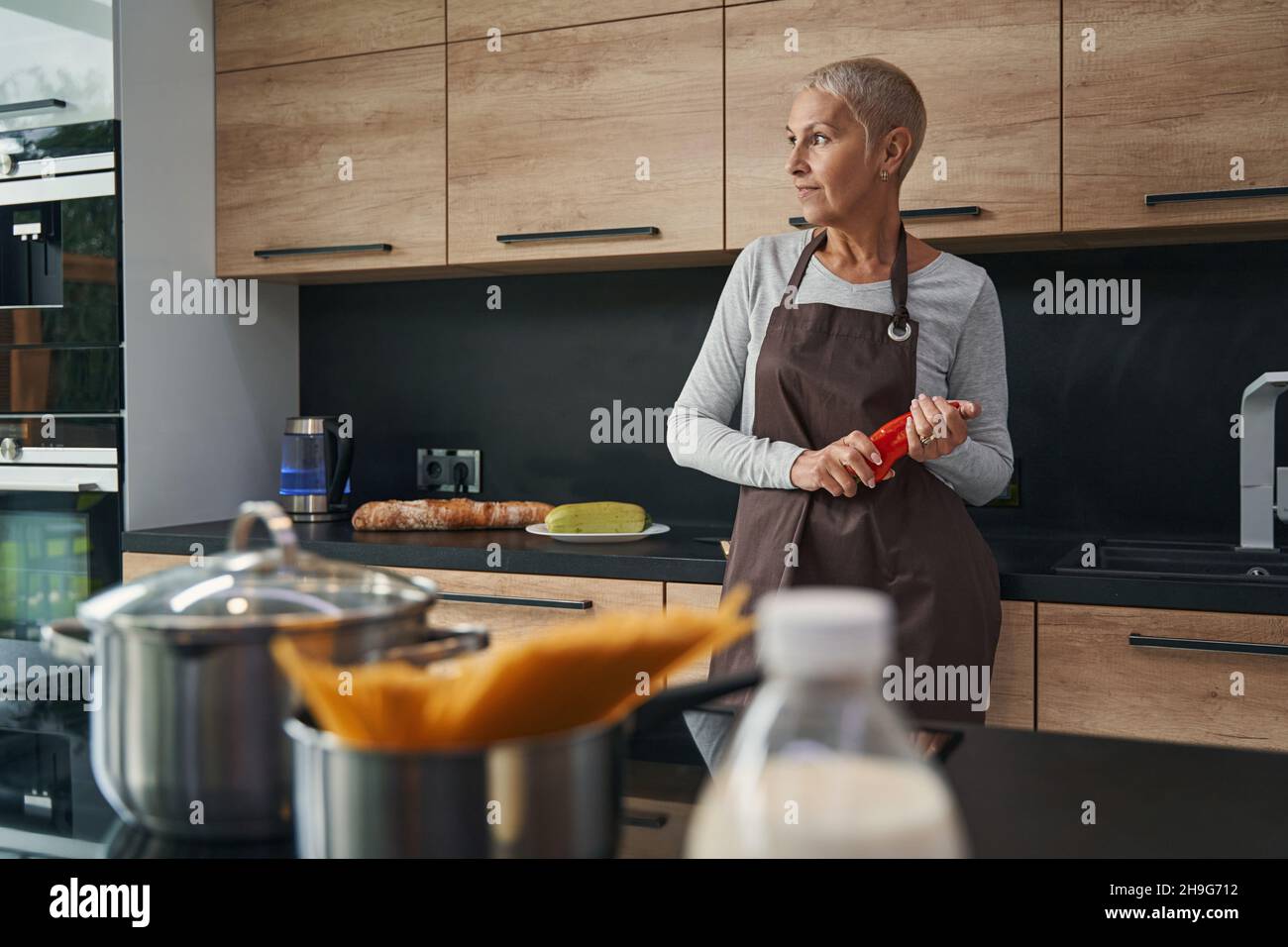 Donna premurosa che guarda da parte la finestra Foto Stock