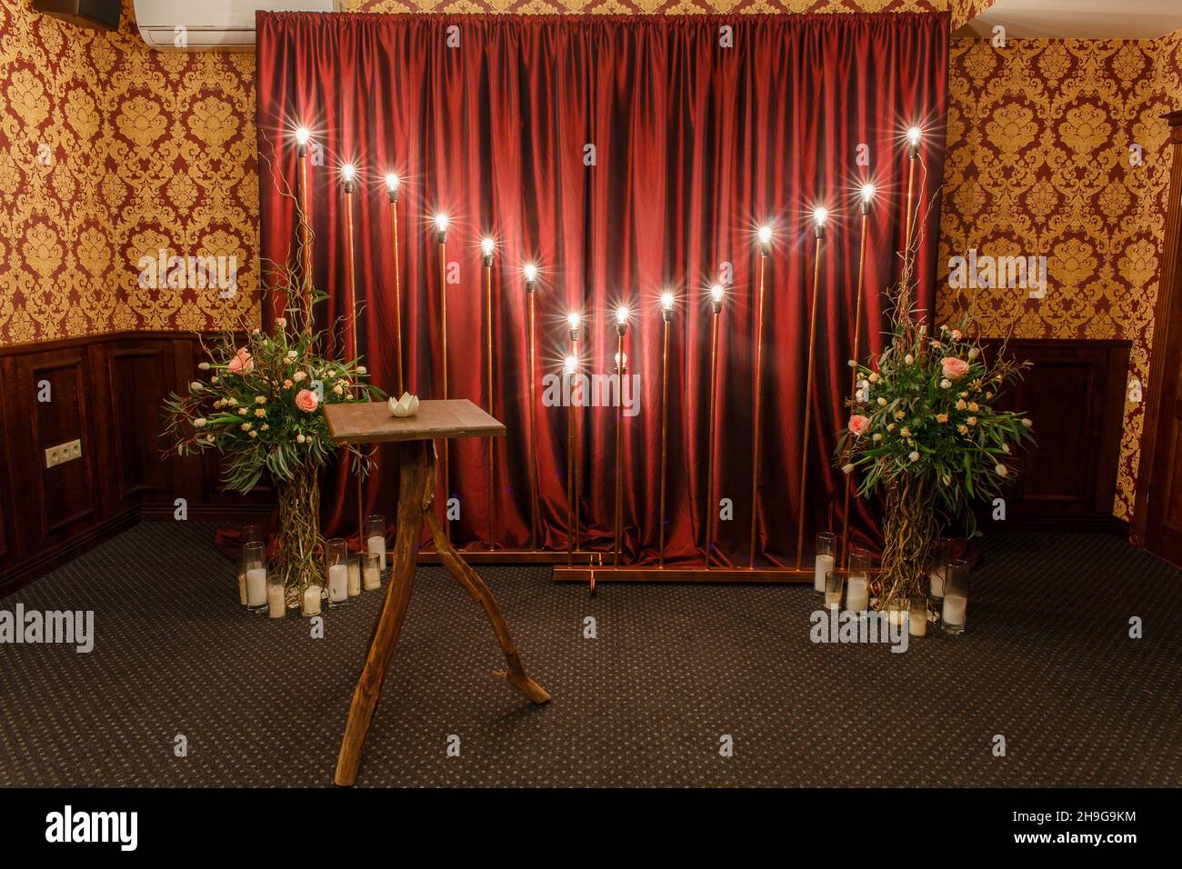 Sala per la celebrazione del matrimonio. Splendidi interni rossi con luci festive. Foto Stock