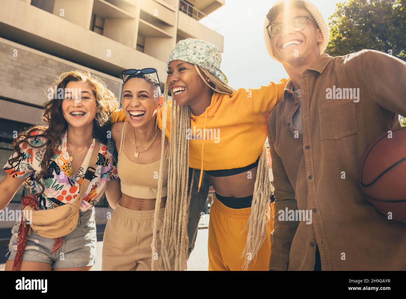 Divertimento estivo. Gruppo di giovani amici felici ridendo allegro mentre si abbracciano all'aperto in città. Generazione z giovani divertirsi a Foto Stock