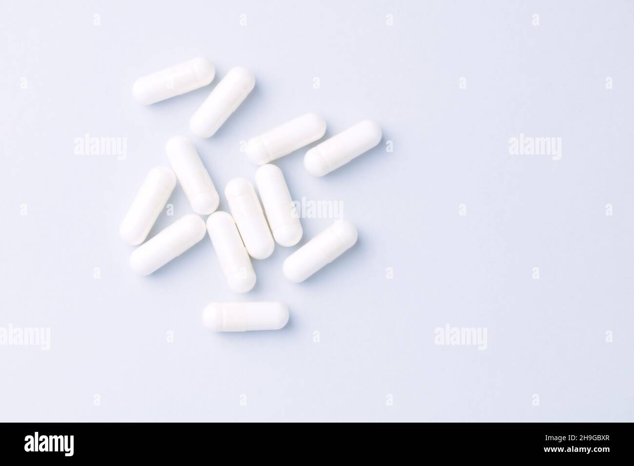Capsule di arginina. Sfondo carta luminoso. Messa a fuoco soft. Vista dall'alto. Primo piano. Spazio di copia. Foto Stock