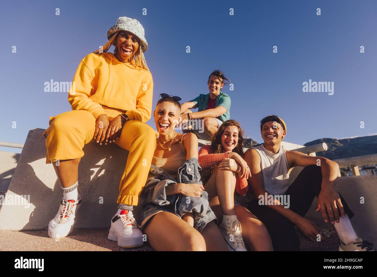 Amici multietnici ridere e divertirsi insieme all'aperto. I giovani felici che si divertono a stendere insieme in città. Gruppo di generazione z frien Foto Stock