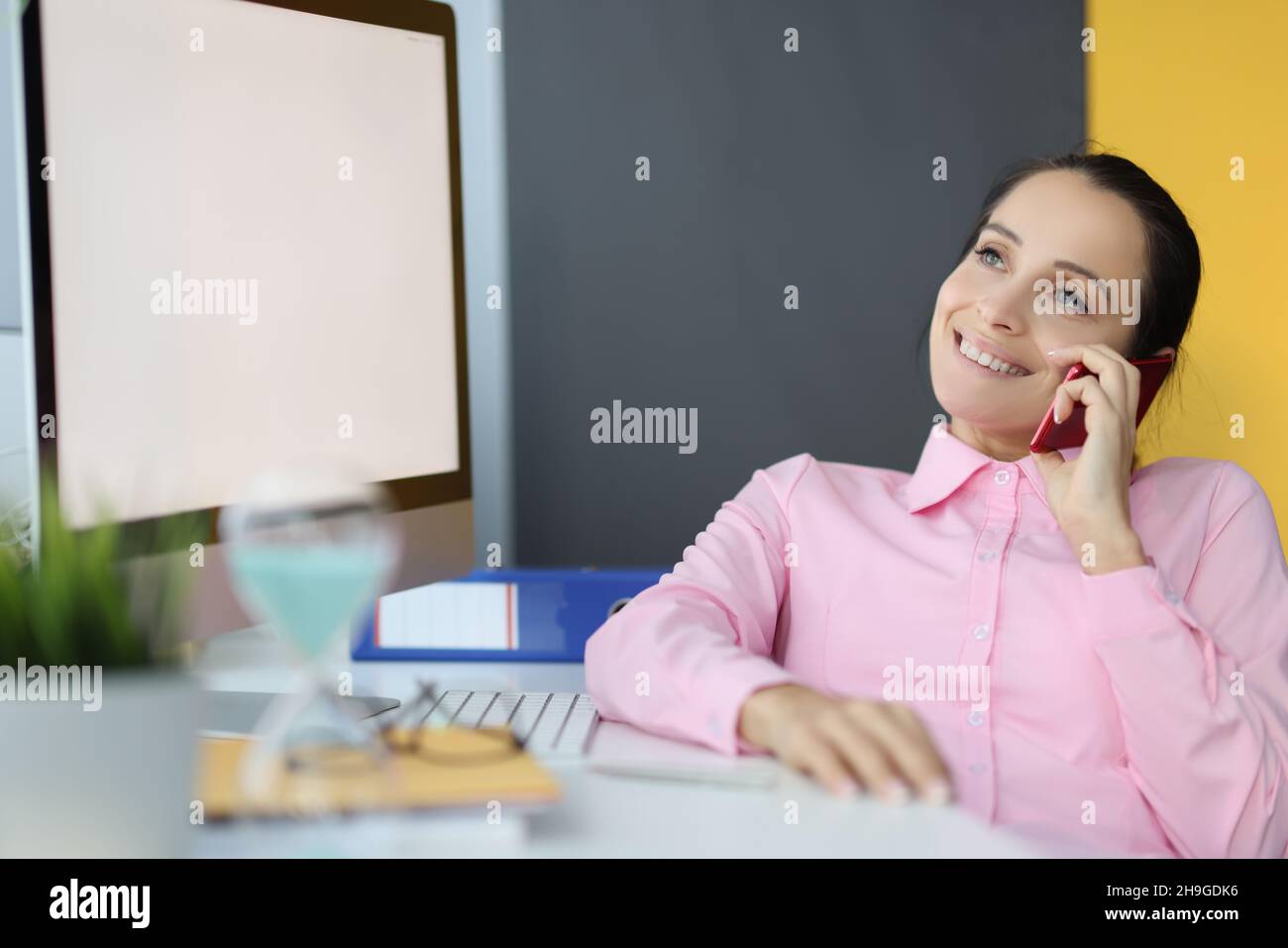 Un buon lavoratore in ufficio che ha fatto una pausa e ha parlato con il telefono cellulare durante il pranzo Foto Stock